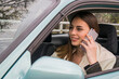 © Ahmed - Young beautiful girl using smartphone while driving car.