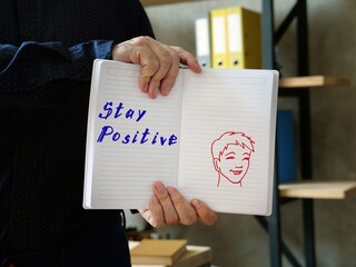Motivation concept about Stay Positive with sign on the sheet.