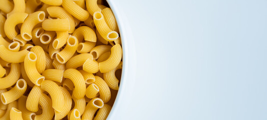 Raw dry uncooked Elbow Macaroni pasta spaghetti on white background. Good for basil tomato pesto sauce Homemade fresh Italian food organic whole wheat vegan spaghetti noodle for a healthy meal