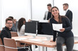 © ASDF - smiling young business woman standing near the desktop