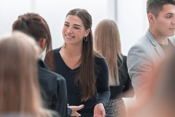 group of young colleagues talking standing in the office