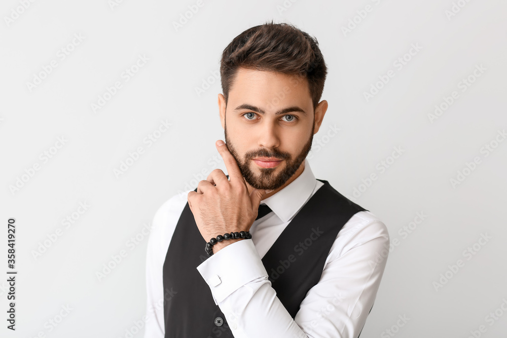 Young man in formal clothes on light background