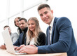 © ASDF - young employee and his colleagues sitting at the office Desk