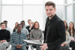 © ASDF - speaker with clipboard standing in the conference room