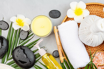 Poster - Spa massage Aromatherapy body care background. Spa herbal balls, cosmetics, towel and palm leaves on gray stone table. Top view, flat lay, overhead, copy space. Beauty and health care concept