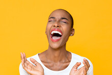 Close Up Portrait Of Happy Young African American Woman Laughing Out Loud With Both Hands In Clapping Gesture Isolated Studio Yellow Background
