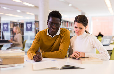 Wall Mural - Portrait of couple of adult students studying together in public library