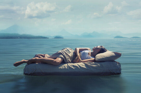 Fototapete - Sleeping woman lies on mattress in a water.