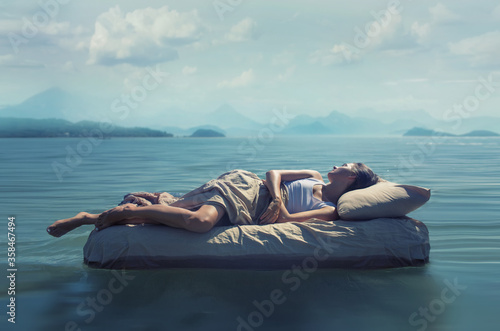 Fotografía Sleeping woman lies on mattress in a water.