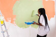© satura_ - Pretty smiling african american woman painting interior wall of home with paint roller. Redecoration, renovation, apartment repair and refreshment concept.