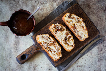 Pieces of delicious pie with nuts and raisins on a wooden Board on a gray background