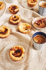 Canvas Print - Vertical shot of delicious Portuguese egg tarts with a cup of espresso on a white table