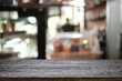© qOppi - Empty wooden desk space platform over blurred restaurant or coffee shop background for product display montage.