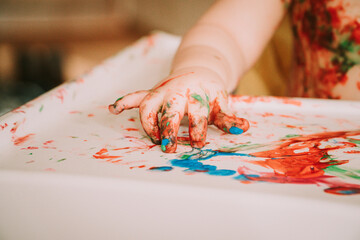 A hand of a baby covered in paint - close up detail image