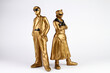 © Maria Letizia Avato - Golden plaster figures of man and woman. Vintage style. The man in a classic suit and sunglasses, the woman in a skirt and shirt with sunglasses and folded arms. White background