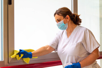 woman disinfecting hospital with mask and protection against coronavirus COVID-19