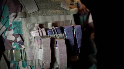 Close up of male soldier's plate carrier with equipment. Body armor concept.