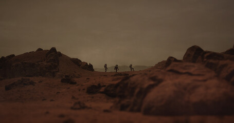 Wall Mural - three astronauts walking on a surface of a red rocky planet. mars colonization concept. planet creat