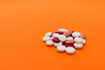 Pile of tablets on orange background.