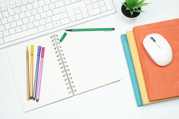 Wall Mural - Flat lay, Top view education and back to school concept on white modern table desk with blank notepad and stack of book, keyboard computer and marker pen, green plant and mouse, stationery