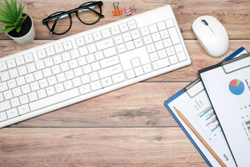 Flat lay, Workspace business office and marketing concept on vintage wooden table desk with keyboard and document graph, eyeglasses and green plant, mouse and supplied, top view with copy space