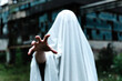 © Alberto Menendez/ADDICTIVE STOCK - Unrecognizable person hand covered in white bed sheet masked as a ghost near old abandoned mine building with rusty metal construction and shabby walls