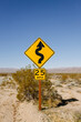 © Luis Tenza/ADDICTIVE STOCK - Yellow speed limit road sign locating in sandy area surrounded by dry grass in desert against clear summer sky in California