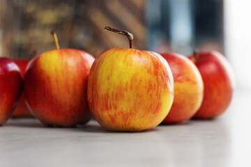 Red apples lie on a light table. Close up