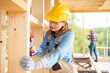 © leszekglasner - Female worker at construction site during work with wood frame house