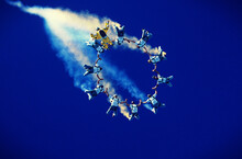 Formation Of Skydivers Trailing Smoke