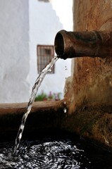 Wall Mural - Close up shot of water coming out of a rusty metallic pipe