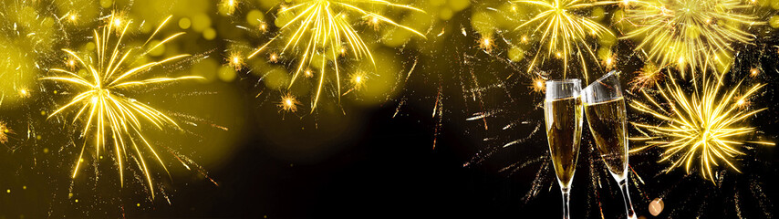 Silvester Party Celebration background banner panorama long- Golden yellow firework and bokeh lights on dark black night texture and two champagne glasses toasting, with space for text