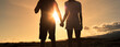 © kieferpix - Man and woman silhouette holding hands together looking at the sunset view.  Couple, love, relationships, and looking to the future.