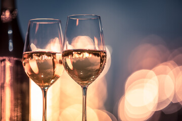 two glasses of wine on table with beautiful bokeh lights background
