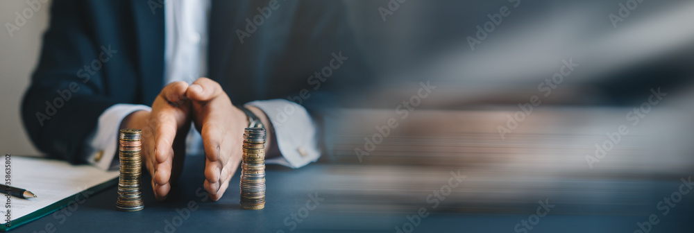 Businessman separates stack coins. Property division. Divorce and legal services. Concept of  saving and investing. Panoramic bussiness banner with copy space. - obrazy, fototapety, plakaty 