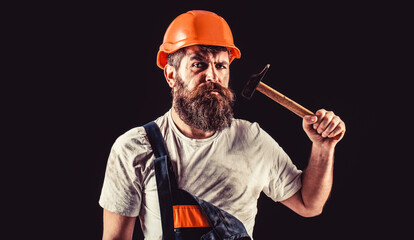 Bearded builder isolated on black background. Hammer hammering. Builder in helmet, hammer, handyman, builders in hardhat