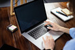 © Rymden - Mockup image of a woman using laptop with blank screen on wooden table