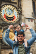 © Masson - Father and son with Czech flag in Prague with city hall and famous watch on background