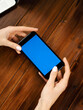 © Rymden - Close up photo of female hands holding smartphone horizontally. Mockup concept with copy space and blank screen