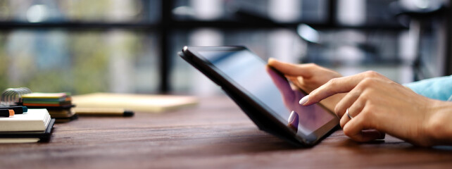 Woman pointing on digital tablet screen, chatting in social networks, meeting website, searching internet, sending sms, using text messenger or online banking. Close up photo