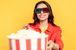 © LIGHTFIELD STUDIOS - selective focus of happy young woman in 3d glasses reaching popcorn isolated on yellow