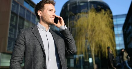 Wall Mural - Business Man Talking on Phone. Close up of businessman Using Smartphone Walking in Big City Business District Street. SLOW MOTION.