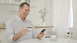 © stockbakers - Online Shopping on Smartphone by Happy Middle Aged Man