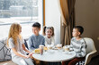 © Andrii - A large friendly company of children celebrate the holiday in a cafe with a delicious dessert. The day of the birth