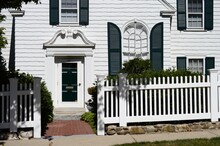 White House With Green Shutters And. White Picket Fence