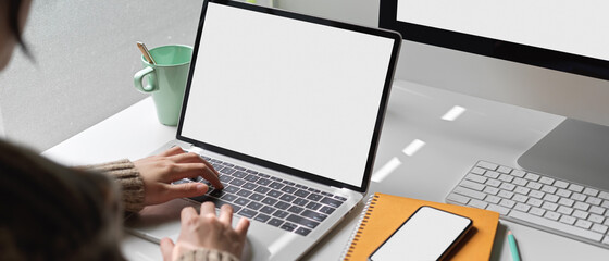Female university student doing thesis with mock-up laptop, smartphone, computer and stationery on white worktable
