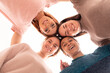 © kalinichenkod - Four happy diverse ethnicity pretty young girls women friends lying in circle look at camera together, sleepover party and multiethnic friendship concept, top view portrait