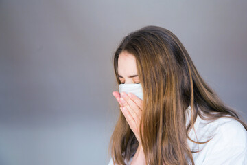 woman in a medical mask on a white background in a medical mask. The patient coughs