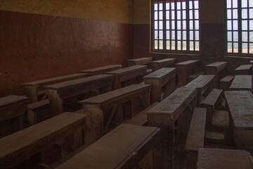 old wooden school benches and desks captured inside an abandoned classroom