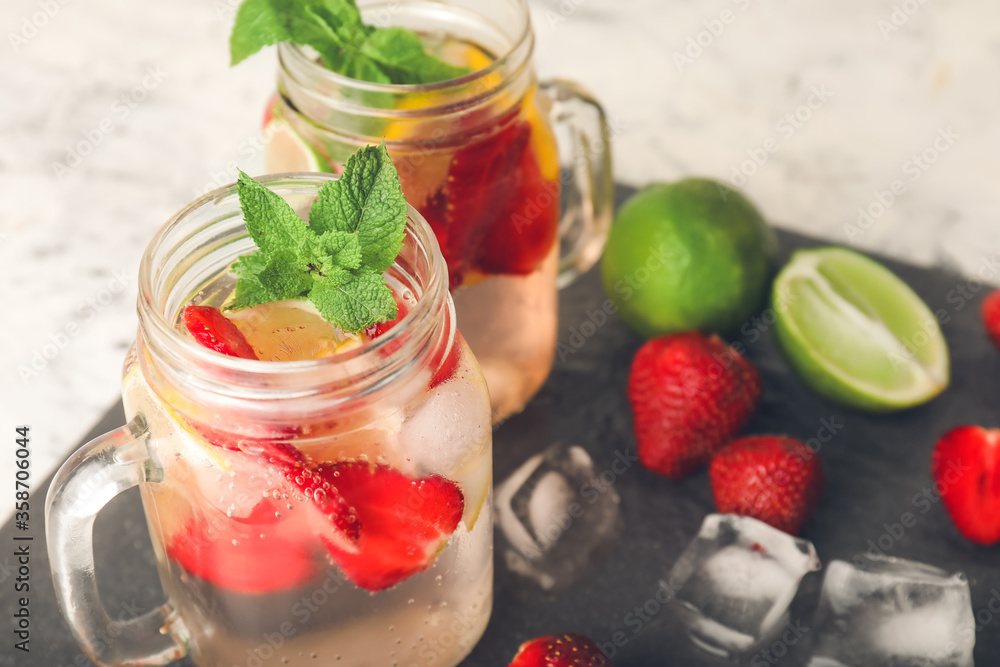Mason jars of fresh strawberry lemonade on table